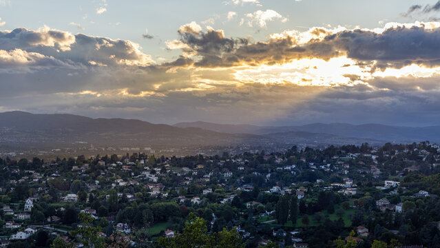 Panoramic Aerial View of Lyon at Sunset with Golden God Rays, Scenic Landscape of Historic French City under Dramatic Sky