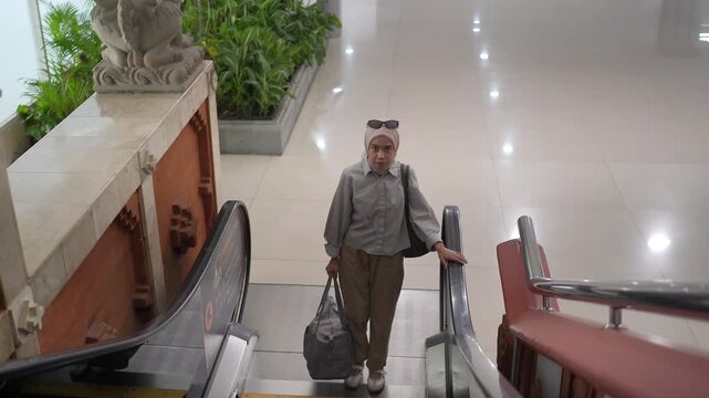 Muslim Woman Riding Escalator in Airport Terminal Travel Lifestyle