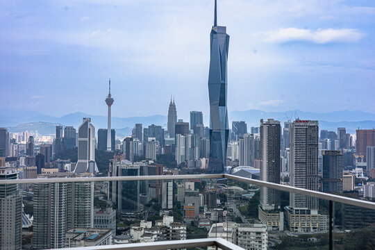 Panoramic skyline of Kuala Lumpur, Malaysia, featuring the Merdeka 118 skyscraper, Petronas Twin Towers, and KL Tower viewed from a high-altitude balcony. Rapid Urbanization