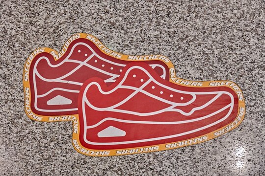 Ambato, Ecuador - June 09, 2025: Skechers shoe advertisement on the floor leading to the store in Mall de los Andes, featuring vibrant red design and eye-catching branding