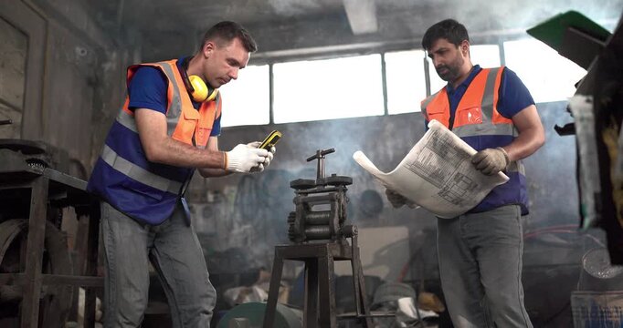 Factory technicians inspect machinery and discuss repair steps in a metal workshop, showing teamwork, maintenance coordination, safety, and industrial support.
