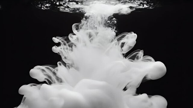 A striking black and white photograph captures the fluid, swirling motion of white ink dispersing in water, creating an abstract and ethereal cloud-like form against a stark black background.