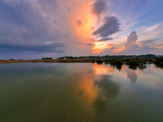 Naklejka premium Scenic Wetland Landscape at Sunset with Beautiful Cloud Reflections on Water with Tree Silhouette