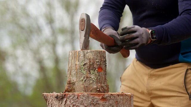Man Splitting The Wooden Logs Using An Axe. - closeup shot