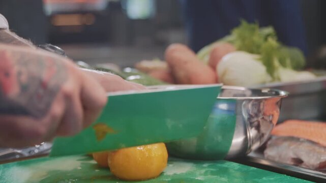 Chef slices tomatoes, Slices of yellow tomato displayed on green cutting surface with kitchen background