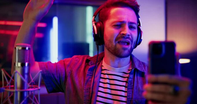 Live streaming, artist and man with smartphone in studio, entertainment and communication with fans. Musician, online and person with mobile for content creation, creative and vlog on social media