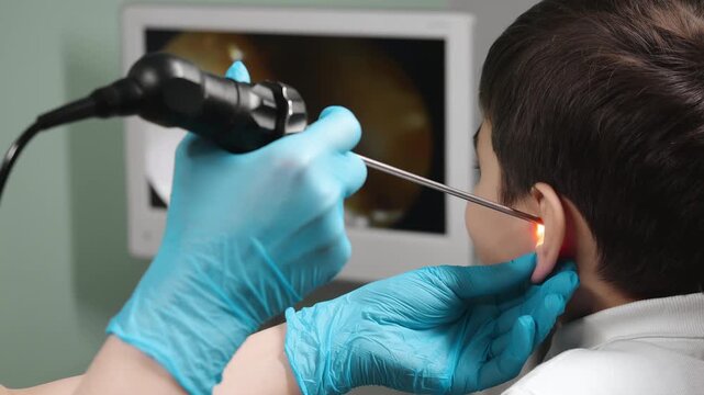 Doctor performing ear endoscopy on child using medical endoscope in clinic ENT diagnostic procedure indoors healthcare technology.