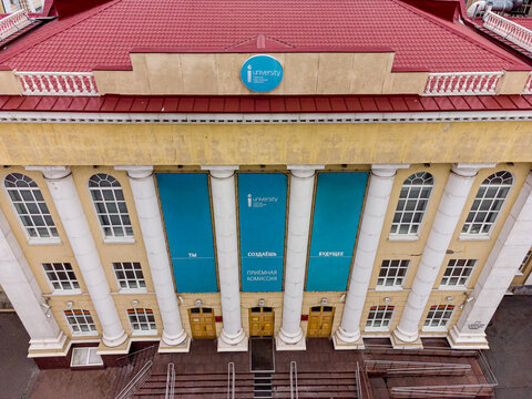 High-angle drone shot (top-down / bird's-eye view) of the main facade of the former Tyumen Machine-Building College (colloquially known as "Mashinka"), now housing the Institute of Industrial
