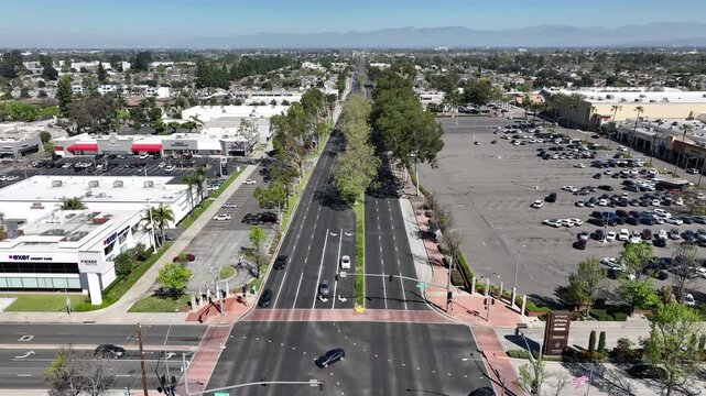 Drone shot of a busy parking lot at a shopping center in Lakewood, CA, capturing vehicle patterns, storefronts, and urban layout from above.