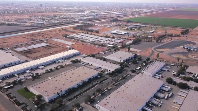 Aerial drone view of industrial parks along the Calexico&ndash;Mexicali border, featuring warehouses, farmland, and the nearby port of entry