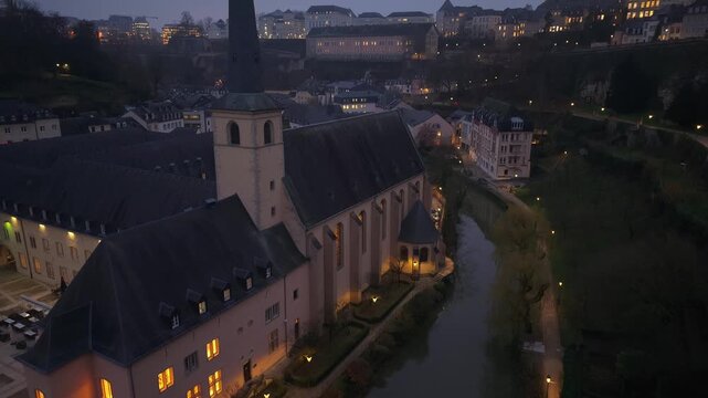 Drone capture of Neumunster Abbey with the Alzette River nearby, revealing the scenic cityscape of Luxembourg with historic architecture and valley views.