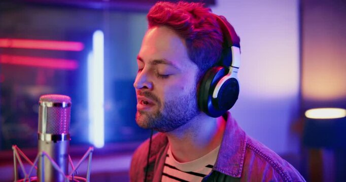 Microphone, man and singer in music booth with headphones for recording song with talent. Musician, media and male artist singing with audio tech for production on album in sound studio on radio.