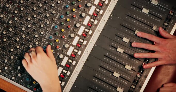 People, hands or audio engineer with sound board for radio production, live streaming or management. Top view, podcaster or team working with control panel for tune, volume or adjusting effects
