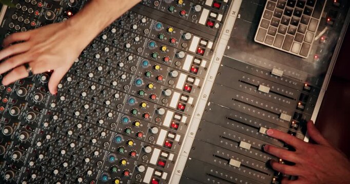 Above, hands and sound engineer in music studio with equipment, change volume and album production. Man, audio technician and creativity with technology for editing track, project and record label.