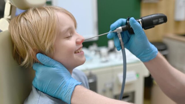 A male ENT doctor examines a patient with an endoscope in the office of a medical clinic. A professional otolaryngologist is at his workplace.