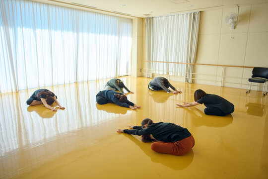 ダンススタジオでストレッチをするグループ