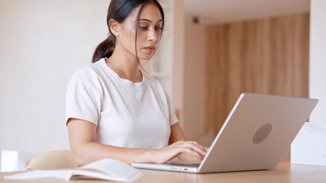 Beautiful Woman Working Remotely On Laptop At Wooden Table. Young Mixed Race Female Professional Typing Important E-mails In Bright Room. High Quality 4K Slow Motion Footage For Business And Success