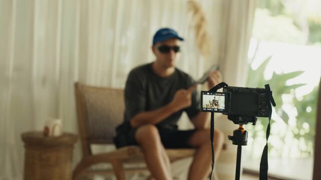 Male blogger recording video content on a digital camera