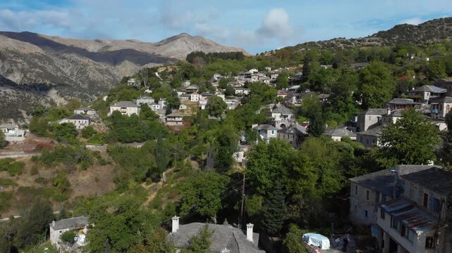A picturesque view of Kalarrytes village, surrounded by lush greenery and mountain landscapes. Ideal for travel documentaries and cultural explorations.