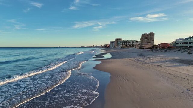 Aerial drone view of empty beach in La Manga del Mar Menor, Murcia. Clear water, coastline, sand and peaceful summer landscape, travel and nature concept.
