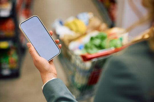 Close up of supermarket customer using app on cell phone.