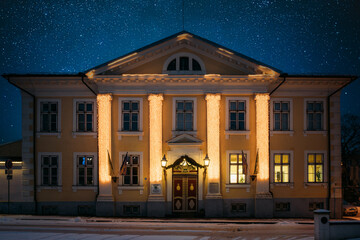 Fototapeta premium Parnu Town Hall with festive Christmas illumination on classical columns during a winter night