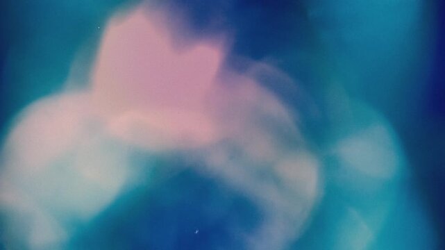 Blurry abstract image with soft pink and blue hues and a white band at the bottom against a dark background.