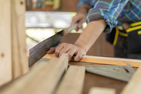 man owner a small furniture business is preparing wood for production. carpenter male recheck design by drawing, architect, designer, Built-in, professional wood, craftsman, workshop.
