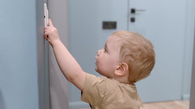 The child turns on and off the lights in the apartment. Teaching self-service skills to young children. Explore about electricity at home