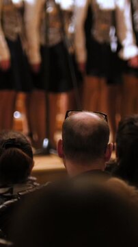 Spectators in concert hall - bald man watching choir of children singers