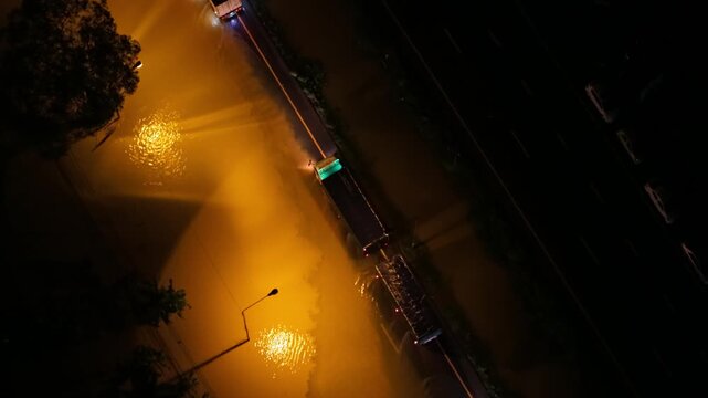 Aerial top view night flooding on road, traffic jam on highway near of city Mu Ban Thep Thani, Chumphom Thailand.