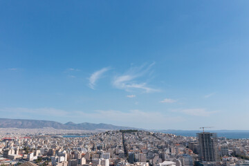 Fototapeta premium Wide panoramic view of Athens city with buildings, mountains and clear blue sky in Greece