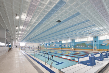 Fototapeta premium Large indoor pool with blue lane water and modern acoustic ceiling