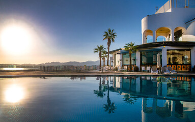 Fototapeta premium Sunset over the pool overlooking the sea 