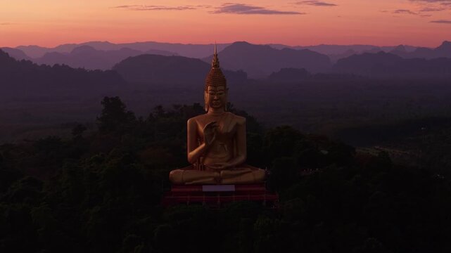 Buddhism monument Gold Big Buddha on Sunset in Thailand. Aerial top view Wat Khao Chedi Wisai Tri Rattanaram.
