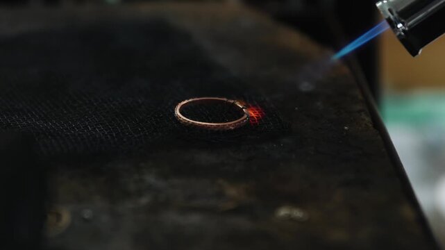 Jewelry maker making a ring with a blow torch in a workshop. Ring craftsman creating beautiful jewelry.