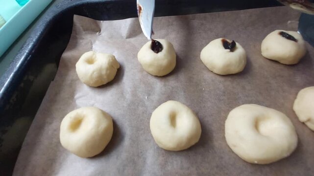 Filling Raw Yeast Dough Buns with Plum Jam Using a Knife 