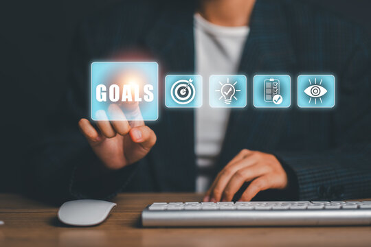 Business professional using digital interface to set goals in a modern office setting.