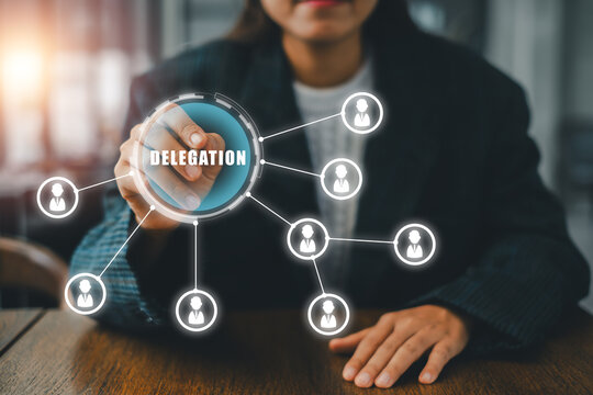 Businesswoman illustrating delegation with a network diagram on a transparent screen, symbolizing teamwork and leadership.