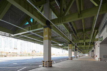Naklejka premium Parking structure with green steel beams and bright side light