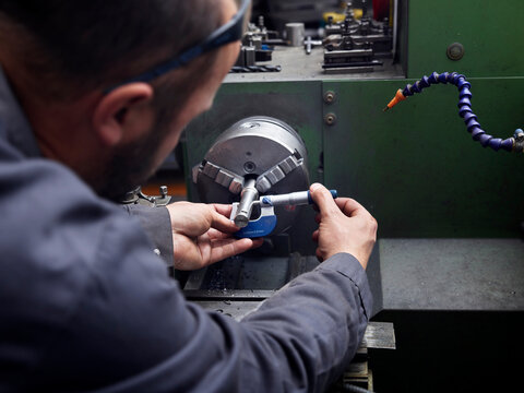 Metal construction technician working at a lathe in a workshop