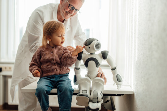 Doctor and child interacting with medical robot in children's hospital