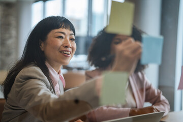 Obraz premium Focused businesswoman organizing sticky notes for strategic planning