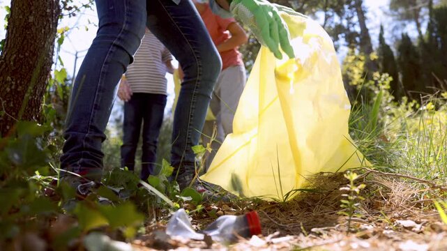 Volunteers collecting plastic waste and cleaning up a polluted forest while collaborating to preserve the environment and fight for a cleaner planet for future generations	