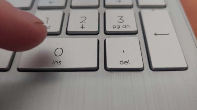 Finger Pressing Number Zero Insert Key on Laptop Numeric Keypad
