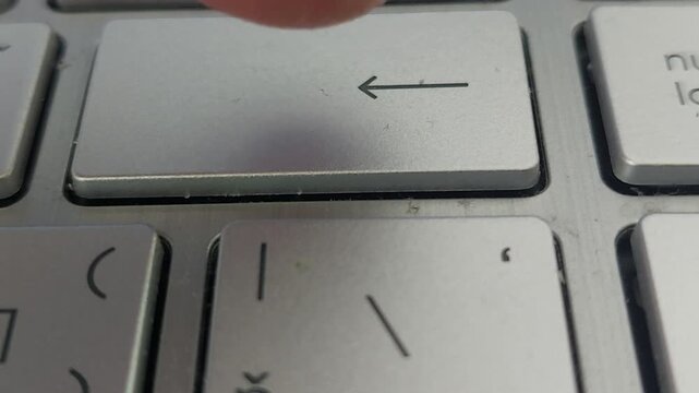 Person Pressing Enter Backspace Key on Laptop Keyboard Close Up