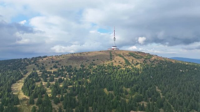 Praded television tower Jeseniky mountain autumn fall aerial drone protected landscape area shot during with spruce trees Picea forest, transmitter birds eye top view footage. Famous tourist place in