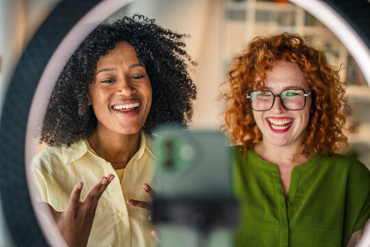 Diverse women friends creating social media content at home