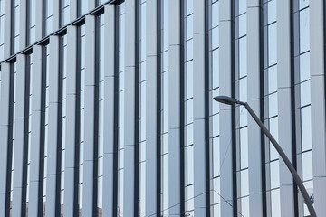 Obraz premium White facade with vertical fins and streetlight in foreground