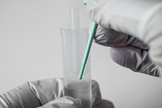 Person uses a swab to collect a sample in a lab